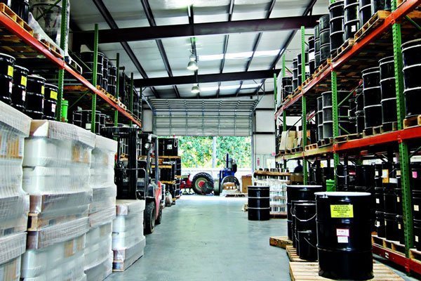 Industriële opslagruimte met pallets en drums met smeermiddelen in een magazijnomgeving